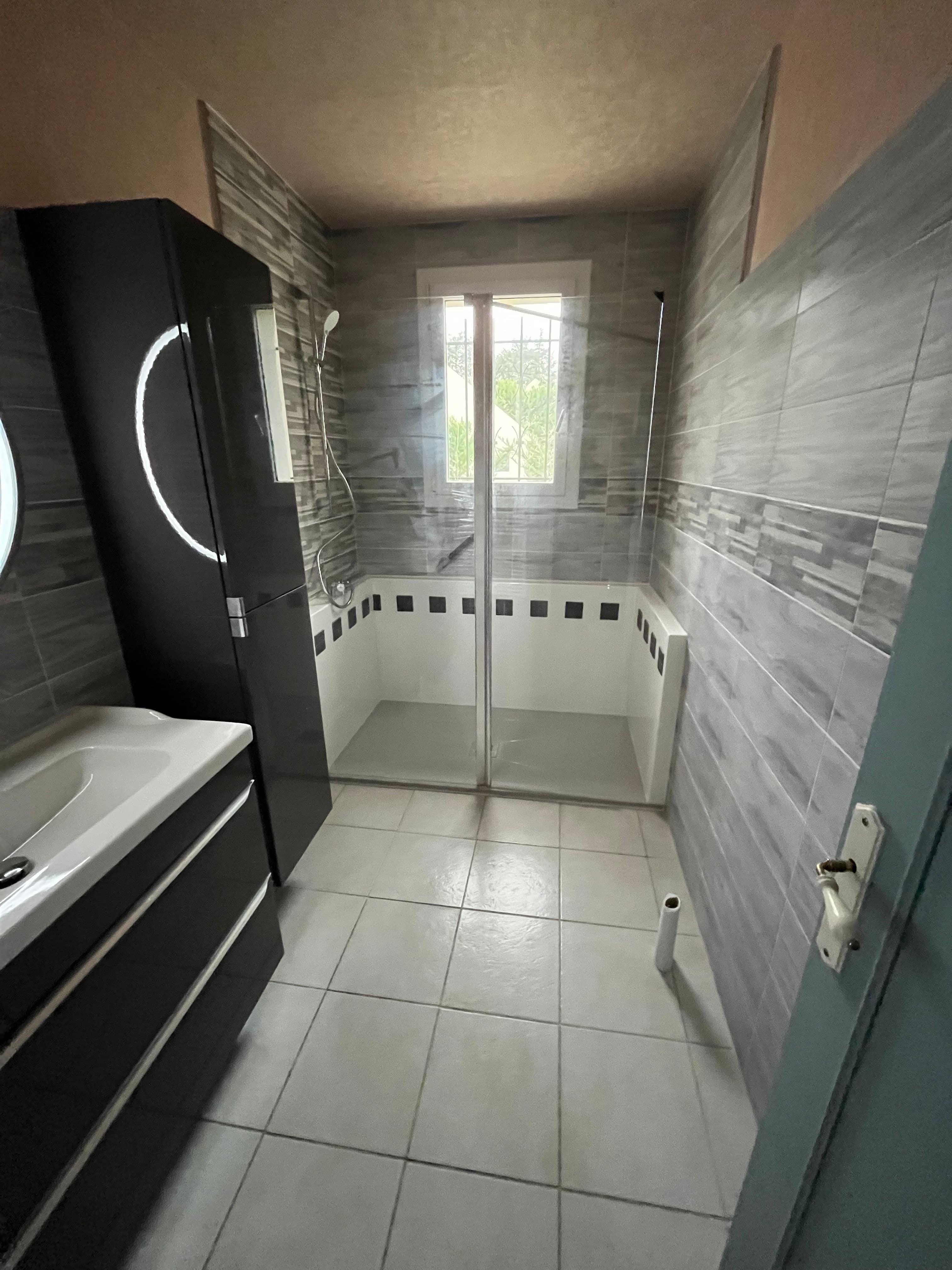 Douche senior de plain-pied avec barres d'appui et sol antidérapant, installée en une journée